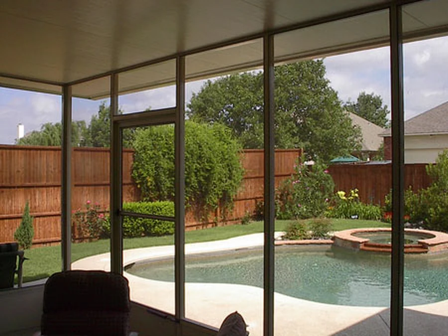 Bright enclosed living space with backyard views